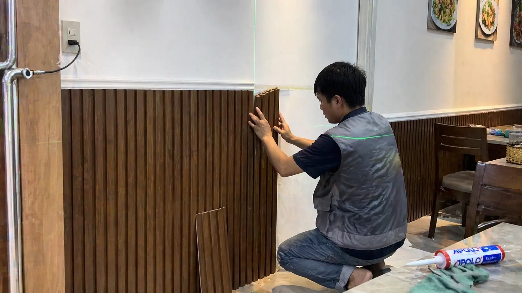 Thợ đang thi công ốp tấm nhựa PVC cho tường nhà hàng nhanh chóng