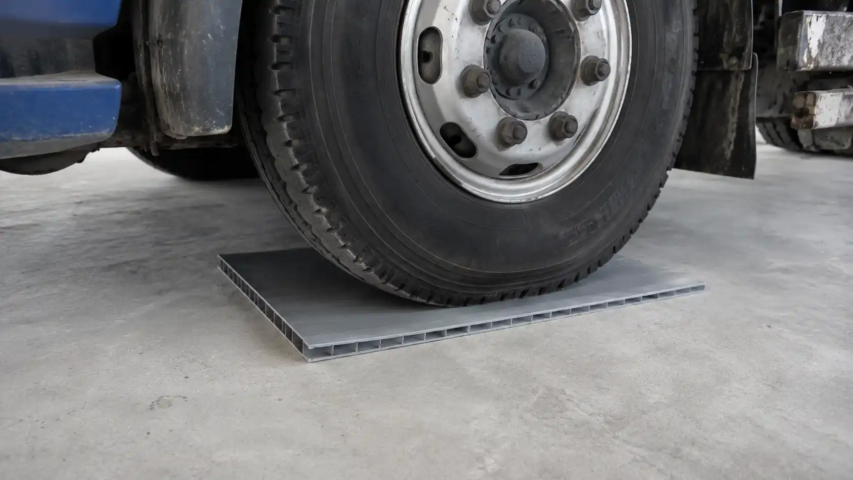 Bánh xe đè lên bề mặt tấm nhựa lót sàn trong điều kiện phẳng tuyệt đối