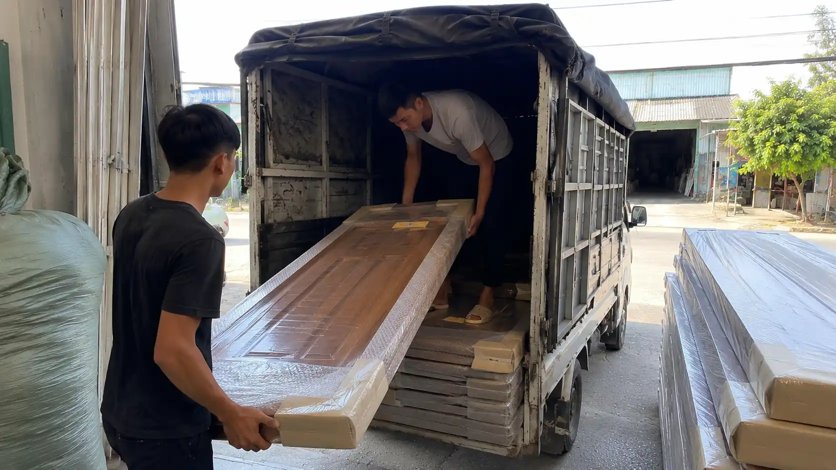 Hoạt động bốc xếp giao sỉ cửa nhựa composite thành phẩm lên xe tải tại kho Nam Tiến