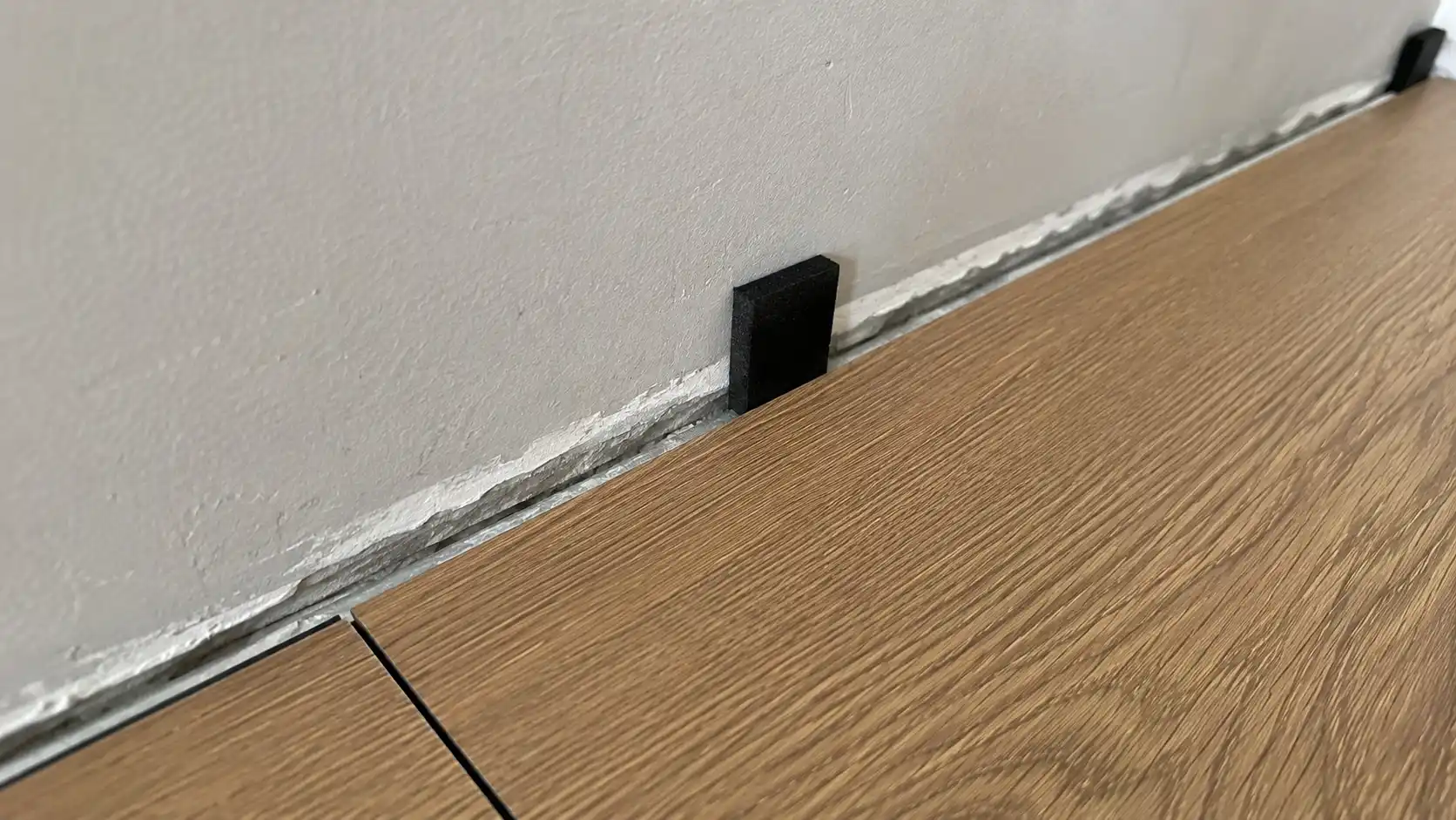 Khe co giãn kỹ thuật 10mm được chừa lại giữa mép sàn nhựa và chân tường