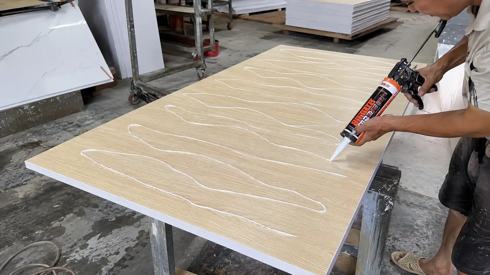 Thợ thi công đi keo dán tấm nhựa ốp tường hình lượn sóng zic-zac