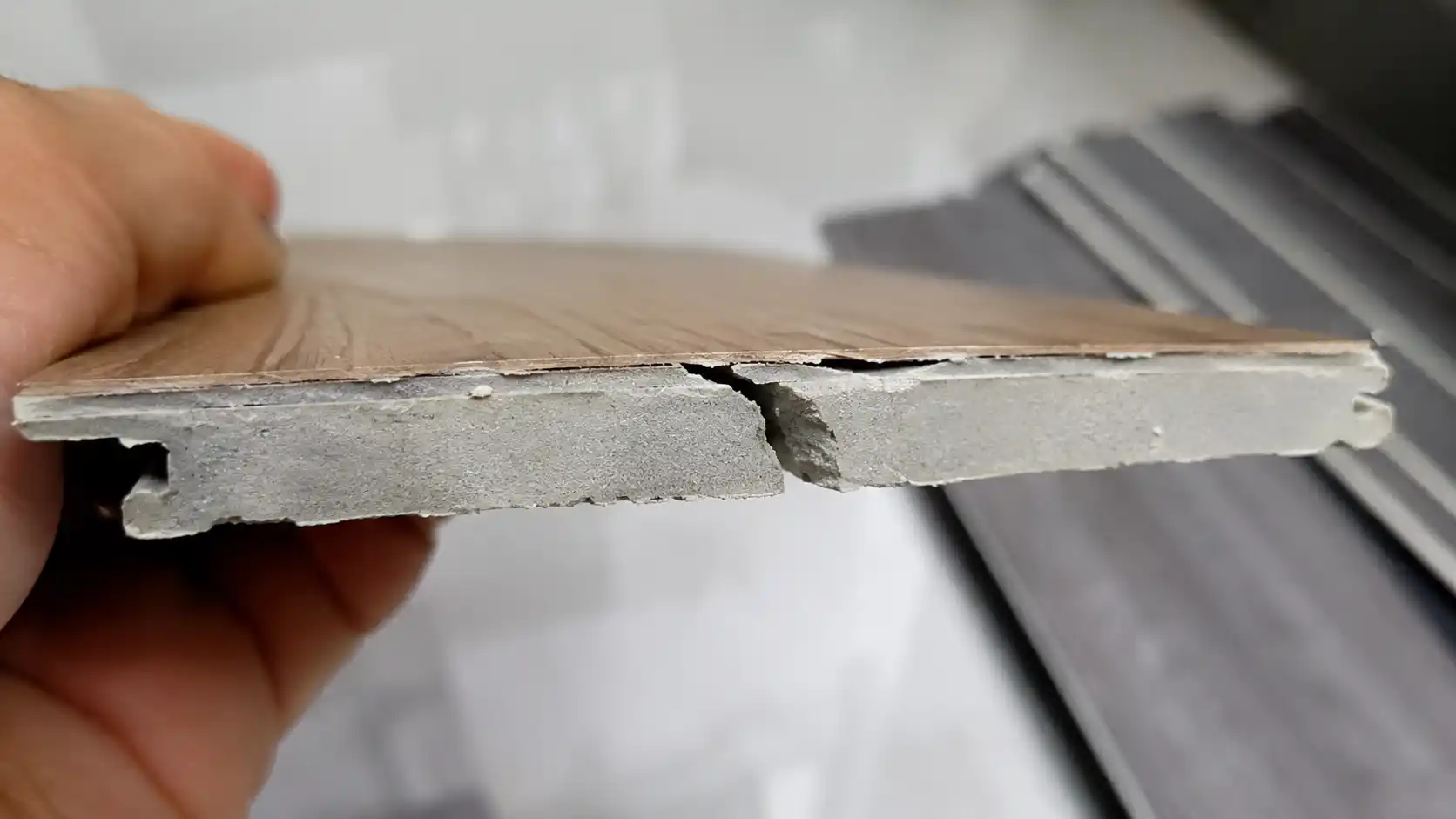 Cận cảnh mặt cắt vỡ kiểm tra lõi bột đá của sàn nhựa SPC