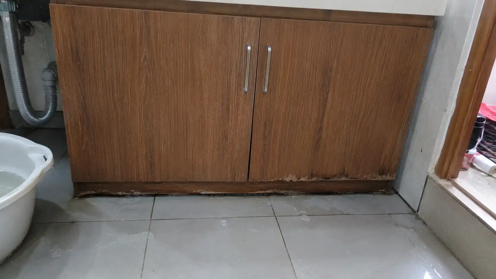 Nước đọng dưới gạch nền ngấm dần vào viền chân tủ lavabo