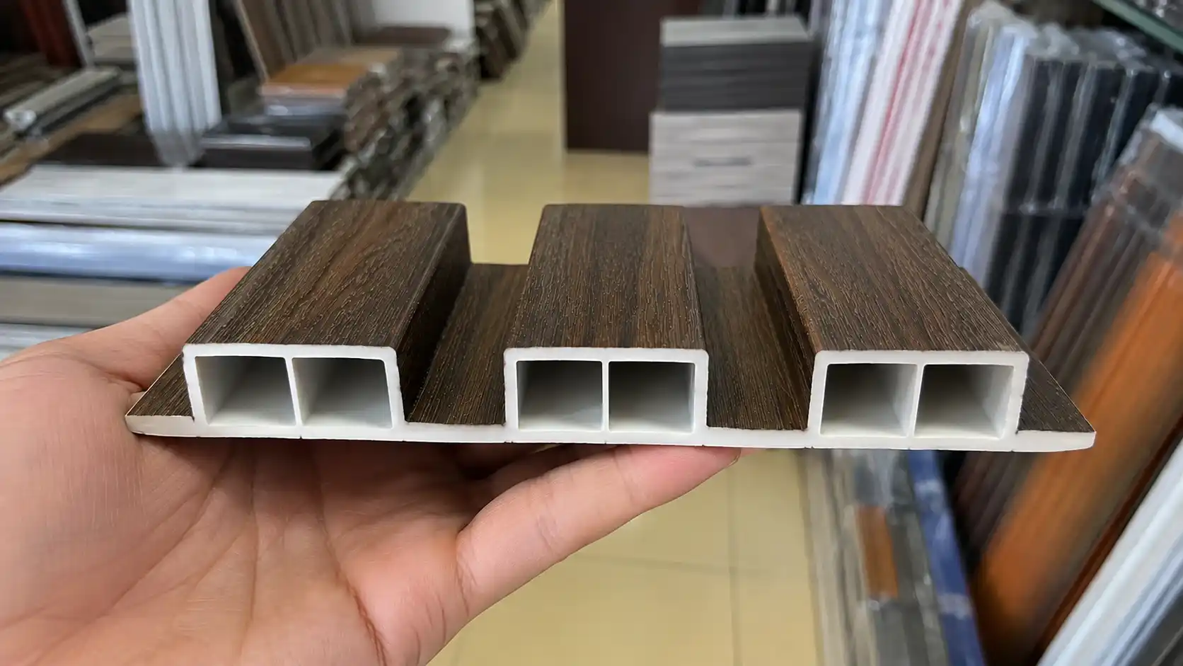 Cận cảnh nếp gờ sóng vuông 3D vân gỗ phẳng mịn của thanh lam nhựa ốp trần nhà phố