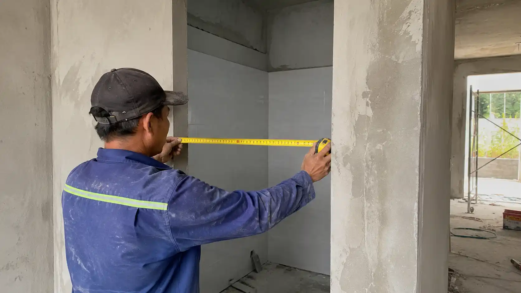 Đo đạc đối chiếu kích thước tường gạch thô nhà vệ sinh trước khi gài nẹp chỉ L