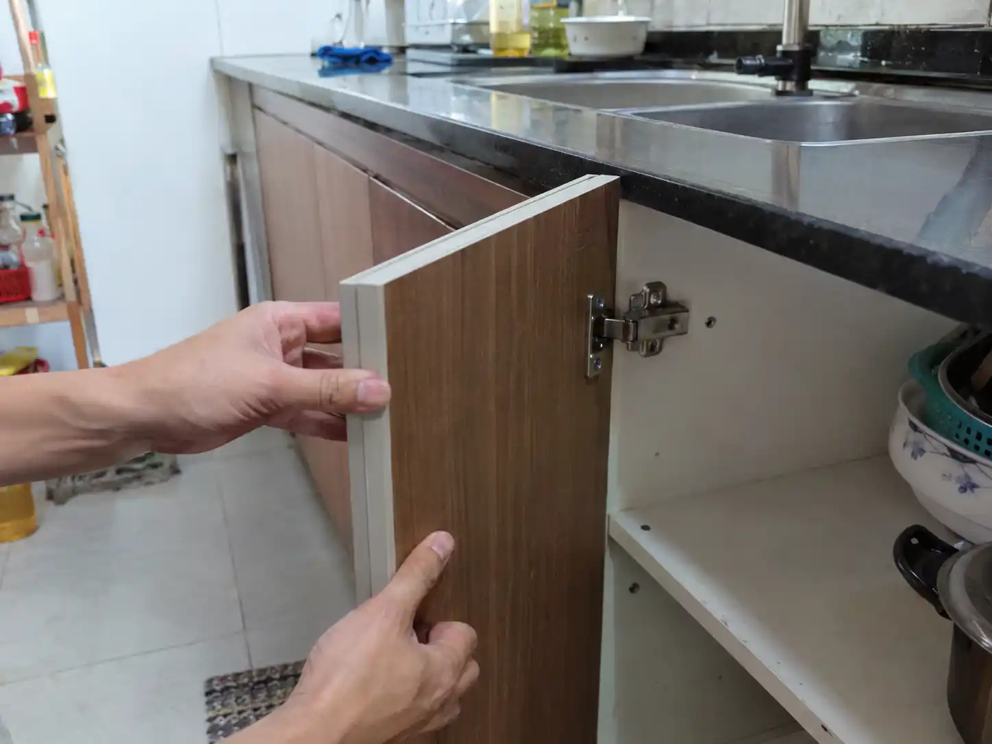 Kiểm tra độ chắc của cánh tủ bếp tại vị trí bản lề
