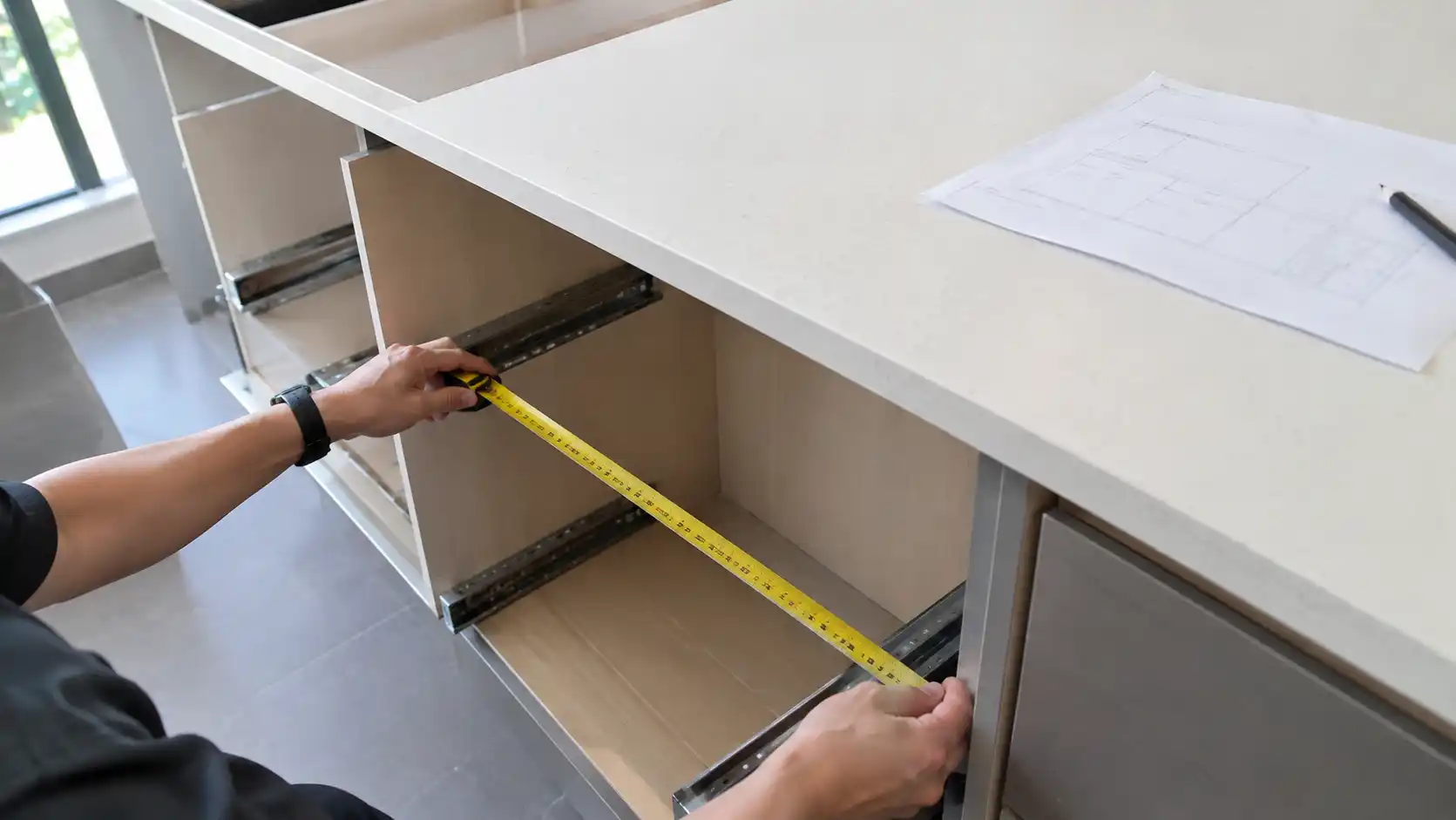 Đo khoang tủ dưới bằng thước cuộn trước khi chọn kích thước kệ dao thớt